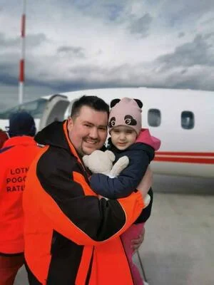 Спасатель HME держит девочку на руках
